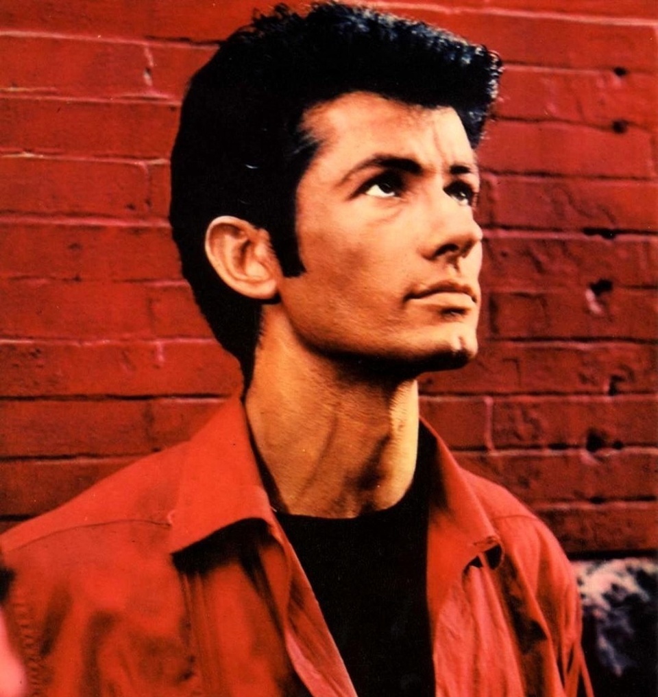 In the opening sequence in "West Side Story," there is an iconic image of George Chakiris. In a close-up, he stands with one hand pressed against a red brick wall brooding with anger after being harassed by members of a rival teen gang, the Jets. Stepping away, he begins to snap his fingers joined by two other Sharks. Then to surging Leonard Bernstein music, the three break into dance, first on a street than framed against the tenements of New York's West Side that were razed after the filming was completed. In this moment, the smoldering Chakiris establishes a formidable presence in this musical retelling of "Romeo and Juliet" set amongst infighting between juvenile gangs in New York. Hollywood agreed, awarding him (along with co-star Rita Moreno) a supporting performance Oscar. Up to that point, Chakiris had been in numerous films, but largely in small roles, usually as a dancer or chorus member in such films as "The Great Caruso," "Stars and Stripes Forever," "Call Me Madam," and "The 5,000 Fingers of Dr. T." He is famously seen in 1951's "Gentlemen Prefer Blondes" as one of the men with Marilyn Monroe in the "Diamonds are a Girl's Best Friend" number. And in 1953 opposite Rosemary Clooney in "White Christmas" performing "Love, You Didn't Do Right by Me." A publicity photo from that scene generated so much fan mail to Paramount that the studio offered him a contract; but unhappy with his career, he moved to New York City in the late 1950s to pursue a stage career. After being cast as Riff in the London production of "West Side Story," he was flown to Hollywood to audition for either that role or his rival Bernardo for the film version, and worked with the show's creator Jerome Robbins for his audition. This led to him being cast in the film, overnight stardom and an Oscar. Then in November of 2012, he had the honor of placing his hand and footprints in cement at Grauman's Chinese Theatre in honor of the film's 50th anniversary. EDGE spoke to Chakiris about "My West Side Story: A Memoir." Tap link in bio to continue on @EDGEmedianetwork ?? (?️: Steve Duffy, ?: George Chakiris / West Side Story / MGM)