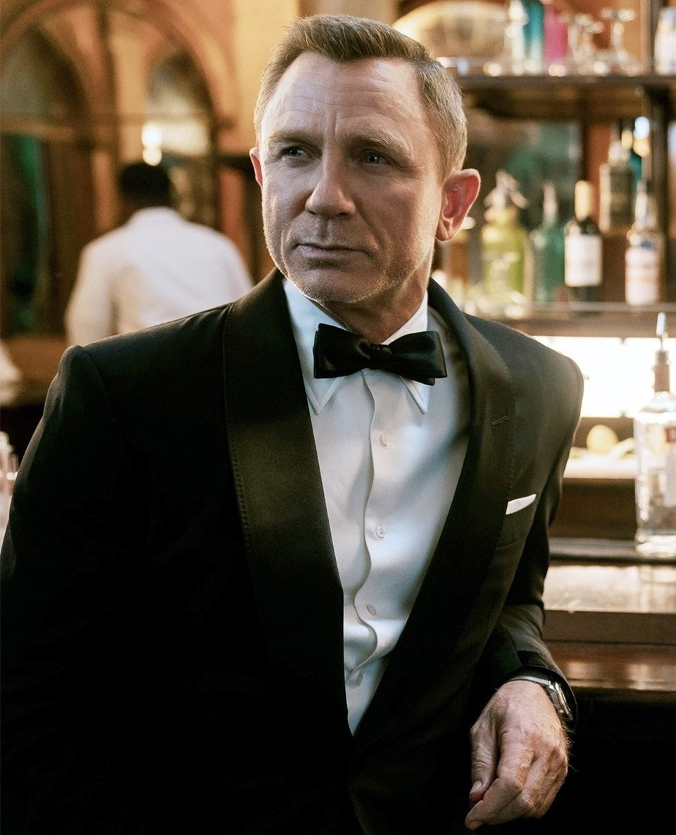 Daniel Craig has jumped back into the James Bond franchise for one last gig, but the character has evolved over the last 15 years — and so has his wardrobe. Esquire notes that Craig's 007 has changed up his sartorial style in ways that make sense for "a man north of fifty," eschewing body-hugging ensembles for "soft, earthy textures" that give off "dad dressing" and "history teacher" vibes. "Craig's Bond has long favored too-tight business tailoring — we know you're muscly, Daniel! - so it's a relief," the article says, to see him take to clothes that are "cut to be at once roomy and flattering," especially when some of the clothes he's rocking in the new flick are by designer Massimo Alba. At one point, as "Bond pilots a launch into harbor," he's looking "very varsity; very JFK," Esquire adds. "A younger, sillier Bond might have opted for neoprene, or something garish and many-pocketed, but Ol' Papa Craigo kept it Hamptons, as any aged sailor with style should do." Craig's graceful aging has influenced the new film in other ways, including the script; as the EDGE review for "No Time to Die" notes, the actor "insisted on bringing in Phoebe Waller-Bridge as co-writer to add humor and sensitivity — as well as a stronger voice for strong women." But Craig also has aged out of the role, which has been notoriously demanding in terms of stunt work and physical conditioning.  Tap link in bio to continue on @EDGEmedianetwork ???? (?️: Kilian Melloy / @dragelruairi / ?: Daniel Craig as 007 in "No Time To Die" / UA/MGM)