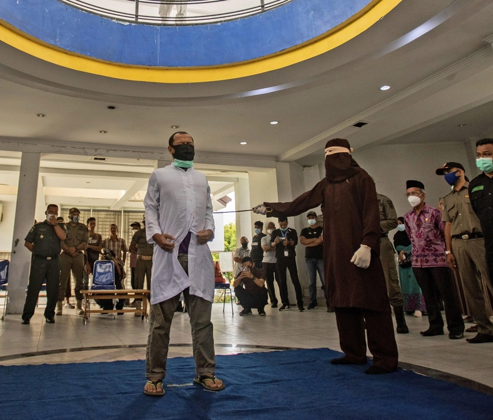 Two men in Indonesia's conservative Aceh province were publicly caned each 77 times Thursday after neighbors reported them to Islamic religious police for having sex. Dozens of people witnessed the caning at Banda Aceh's Tamansari city park. It's the third time that Aceh, the only province in Indonesia to practice Shariah law, has caned people for homosexuality since the Islamic law was implemented in 2015 as a concession made by the government to end a long-running separatist rebellion. The men, aged 27 and 29, were whipped across the back and winced with pain as a team of five enforcers wearing robes and hoods took turns, relieving one another after every 40 strokes. The men were arrested in November after residents became suspicious and broke into their rented room where they were caught having sex, said Heru Triwijanarko, Aceh's acting Sharia police chief. A Shariah court last month sentenced each man to 80 strokes, but they were caned 77 times after a remission for time spent in prison. Tap link in bio to continue on @EDGEmedianetwork ???️‍??⁠
⁠
?: A Shariah Law official uses a rattan cane to whip one of two men convicted of gay sex in Banda Aceh, Aceh province, Indonesia / AP Photo / Riska Munawarah