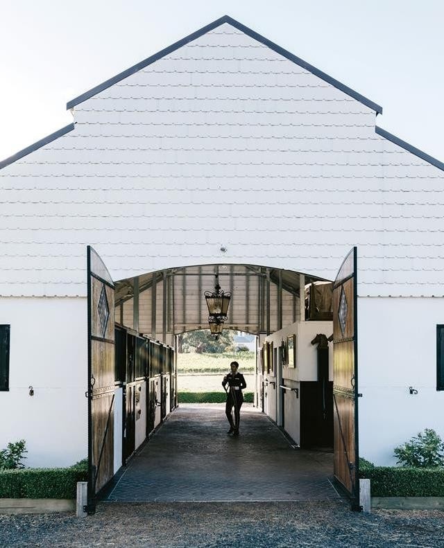 For accomplished dressage rider Meaghan Willis, building a Dutch-style stable for her beloved warmbloods Harry and Romeo, was a dream come true. Take a tour of her beautiful formal garden (which overlooks Hanging Rock in the Macedon Ranges) by clicking the link in bio. ⠀
.⠀
 #gardendesign⠀
#horsebarn⠀
#horsesofinstagram⠀
.⠀
Words: @virginia_imhoff⠀
Photo: @marniehawson