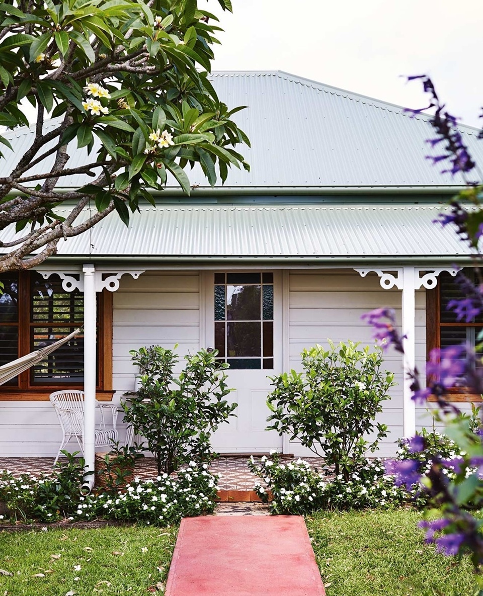 Once the manse of a church, this century-old weatherboard cottage, known as The Art House, is both a boutique hotel and an art gallery. ⁠
⁠
While guests here can experience art hung inside a home, that's not where the beauty ends. A sensitive restoration means the home itself has retained many original features including wooden floors, pretty fretwork detailing and a tiled front verandah. ⁠
⁠
Step inside by tapping the link in our profile. ⁠
⁠
Photography: @aliciataylorphotography⁠
Styling: @shannonfricke⁠
⁠
#byronbay #cottagestyle #homeexterior #frontdoor #frangipani #frontgarden