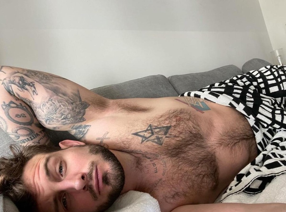 Nico Tortorella once said they have "too many [tattoos] to count," but their latest ink is hard to ignore. The 33-year-old "Younger" star revealed a new tattoo this past weekend — a graphic, ink design that stretches from neck to heel, reports People magazine. "Younger" recently completed its final season on Paramount+ and coincidently, Tortorella played a tattoo artist on the show. They revealed the tat on their Instagram Stories Friday, complete with a pic of their backside showing the entire tattoo, which begins at their neck, runs down the middle of the back and then moving to their right side shadowing their buttocks before running down their right leg to their heel. "Inspired by the one and only @bethanycmeyers," Tortorella wrote under their video, tagging their spouse, who has a similar line tattoo. Tortorella called himself "sexually fluid," identifying as bisexual in 2016. They married Meyers in 2018. Along with the full-body footage of their tattoo, Tortorella also included a photo of their new ink, writing, "We love a freehand outline" and tagging tattoo artist @fcknrx, who shared their own photos of the star's new body art on Instagram. Tortorella talked about the tattoo with People. "If I wasn't a full-time actor, I think I would be fully covered. I get tattoos all the time. My agents want to die. They gave up hassling me a long time ago," the actor said. "The art of tattoos, historically, is one of the most sacred practices. I'm really strongly connected to the ancient practices of tattoo work — not just, 'Oh, it's cool to get tattoos now.'" ???? Tap link in bio to continue on @EDGEmedianetwork (?: Nico Tortorella / Instagram / @nicotortorella)