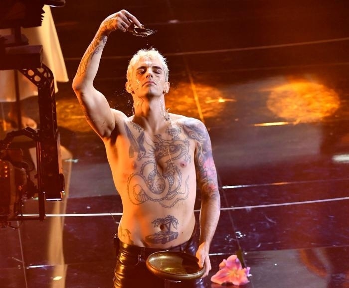 The Vatican and an Italian Catholic bishop this week protested a performance at Italy's Sanremo music festival that featured a "profane" faux baptism on stage, lamenting in particular that it was broadcast on public television. On the opening night of the annual song contest, a tattooed, bare-chested and barefoot singer named Achille Lauro gyrated and grabbed his crotch as he sang "Domenica" ("Sunday"), backed up by singers from the Harlem Gospel Choir. He finished by kneeling on stage, hands clasped in front of him as if in prayer, and poured water from a bowl over his forehead. Sanremo Bishop Antonio Suetta said the performance contained "words, attitudes and gestures that are not just offensive to religion, but to human dignity." Lauro said in comments on his Instagram feed, which has 1.7 million followers, that he wanted to give his opening night performance at Sanremo to his mother as a birthday present. "Mothers are divine beings, they give us life everyday, today in a new beginning, I give you my baptism," he wrote in a post that had over 2,000 comments.⁠
⁠
Tap link in bio to continue on @EDGEmedianetwork⁠
???????⁠
?: ACHILLE LAURO® / @achilleidol / AP