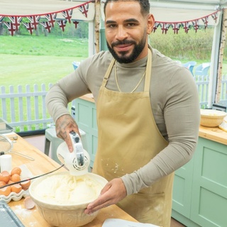 His name is Sandro Farmhouaw and he's an out, tatted and bearded, 30-year old nanny living in London. He's also the break-out star of 2022 edition of Netflix's "The Great British Bake Off."And is in a relationship, having introduced his boyfriend in one episode. It didn't take long for fans to call him "cake daddy" and "the great British baking snack." While one fan wrote they "can't wait for Bred Week" — with intentional misspelling. On the show's website, he is described as being born in Angola, but came to London to feel the war in his country with his mother. He made an impression on the show's opening episode by showing off his fitness routine. Trained in boxing and ballet, he says he turned to baking as a form of therapy after his dad died when he was 21. "Now, he lives and breathes it, and is often found rustling up bakes in a relaxed vibe with the telly on, or running virtual baking classes for children with autism." Working with children is important for Farmhouse, whose name suggests a vision of bucolic country residence. Working with the group Social Ark, prompted Sandro to create baking and cake decorating workshops for autistic children. "Social Ark has introduced me to real community leadership. I am passionate about creative baking and supporting children and young people with special needs to flourish. I'm full of aspirations and really looking forward to the future, being part of Social Ark and wherever my baking journey takes me."⁠
⁠
Tap link in bio for more on @EDGEmedianetwork ⁠
????⁠
?: @sandrosbakes
